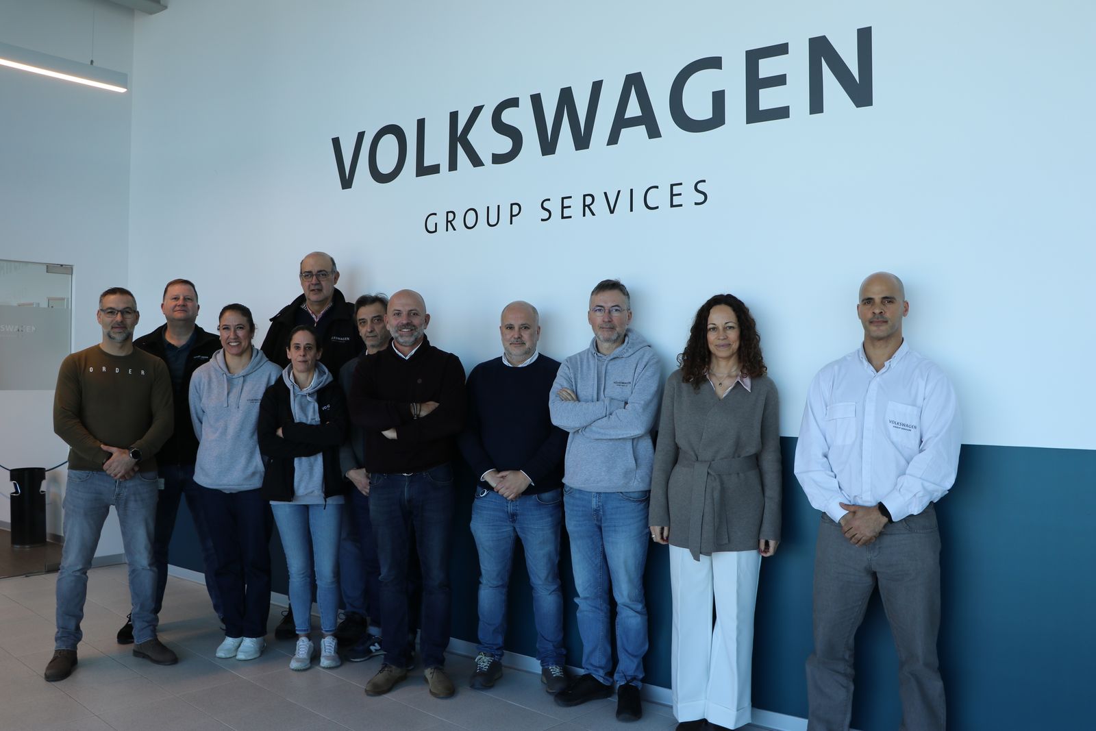 Grupo de pessoas em frente ao logótipo da Volkswagen Group Services